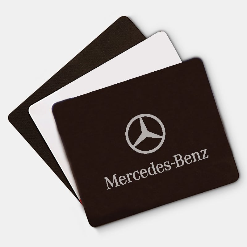 A set of three mouse mats in black, white, and grey, featuring a logo on the front of the black mat.
