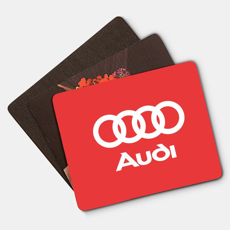 A set of three mouse mats in various colours, including a red one with a logo and two in darker tones.