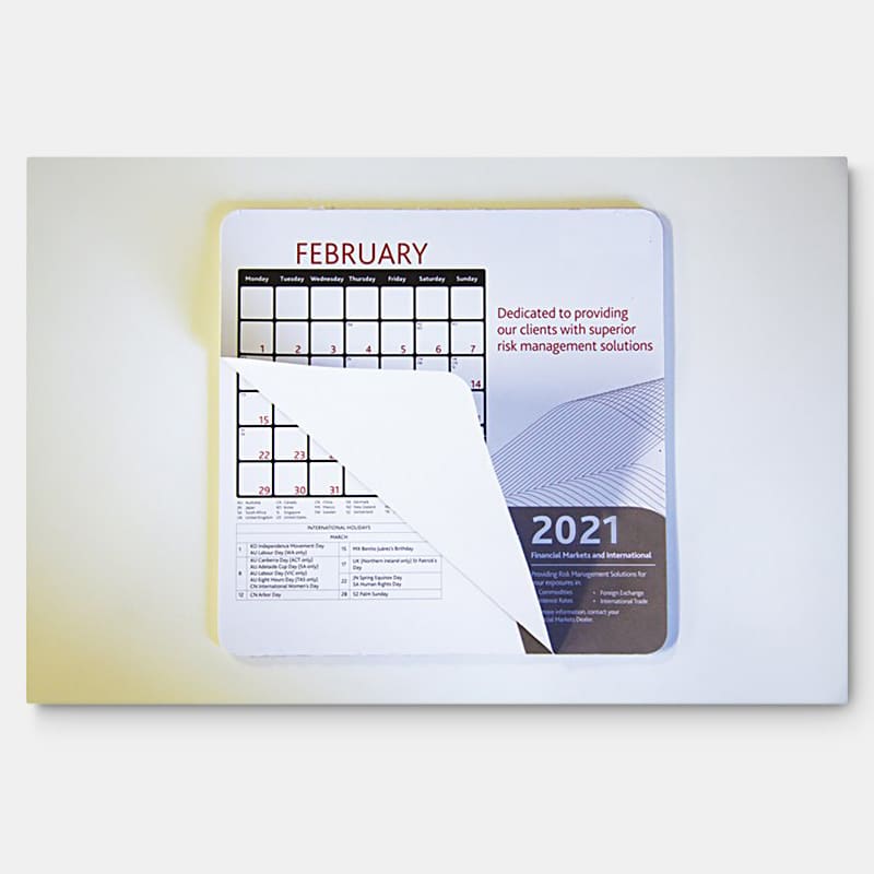 A mouse mat featuring a calendar layout for February 2021, with a white background and a logo in the corner.