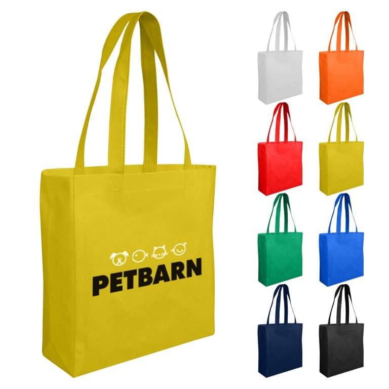 A yellow non-woven small shopper bag with long handles and a logo, surrounded by bags in various colours.