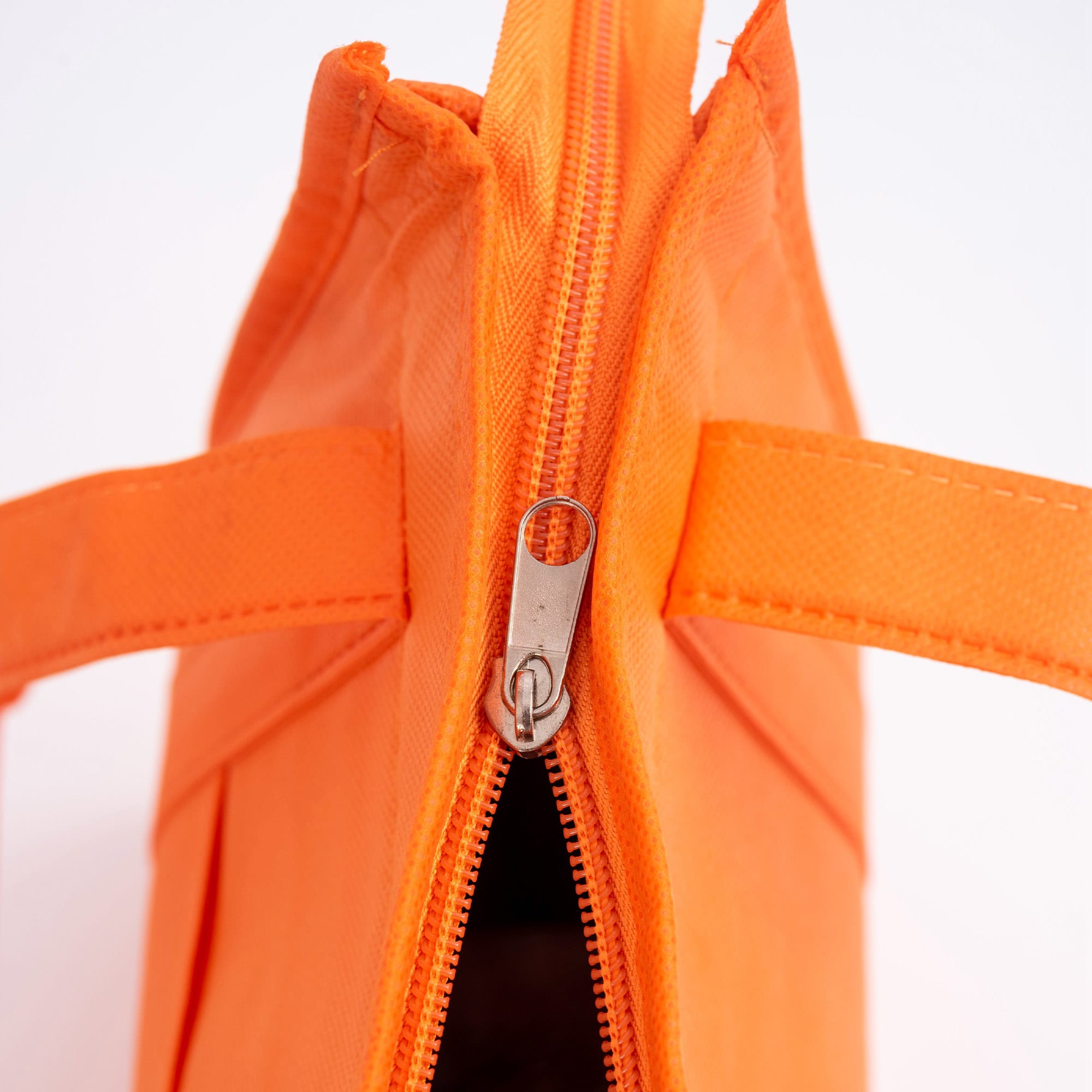An orange non-woven cooler bag with a top zip closure and two handles. It has a simple design and a logo.