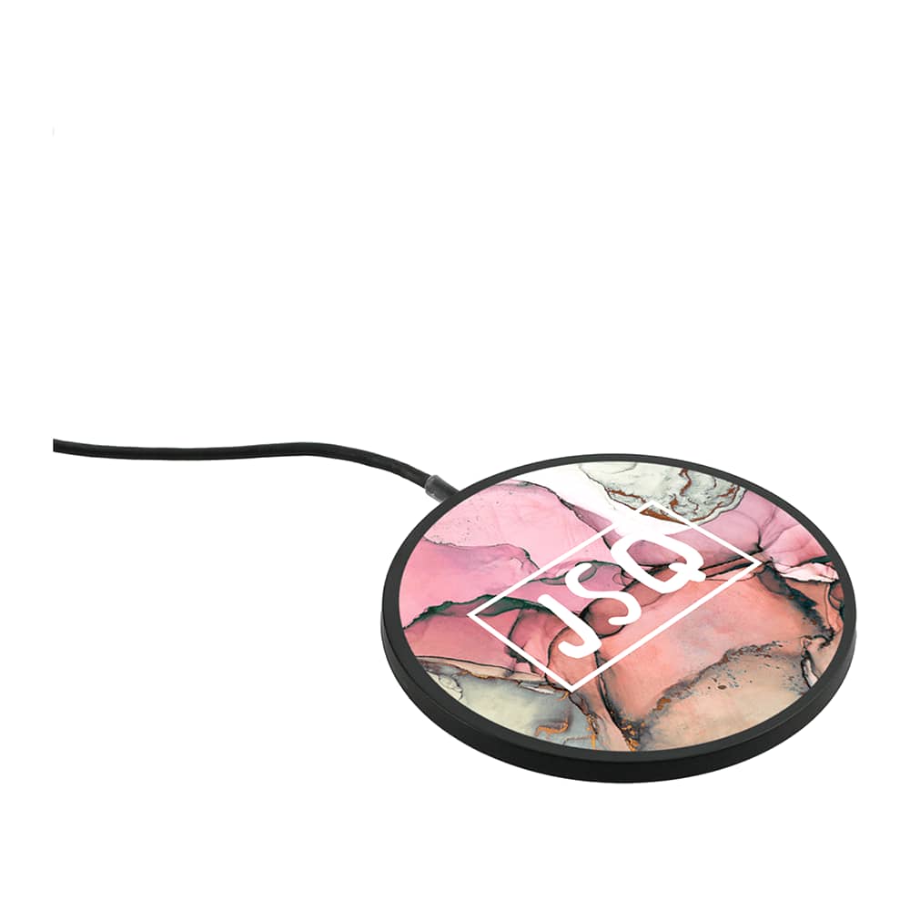 A circular wireless charging pad with a multi-coloured pink and black abstract design, featuring a logo.