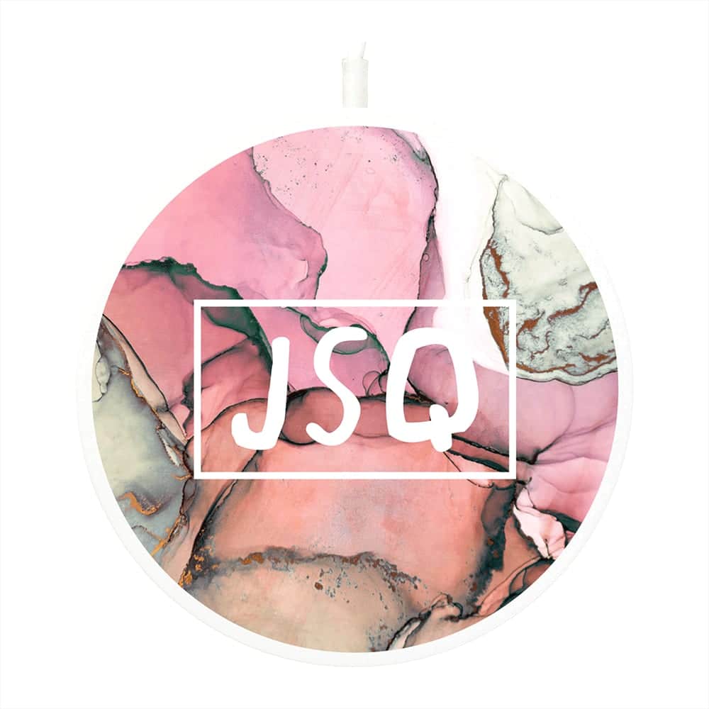 A round wireless charging pad in pink and marbled grey, featuring a logo in the centre.
