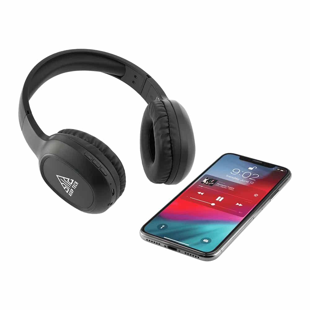 Black Bluetooth headphones with a built-in microphone beside a smartphone displaying a music player interface.