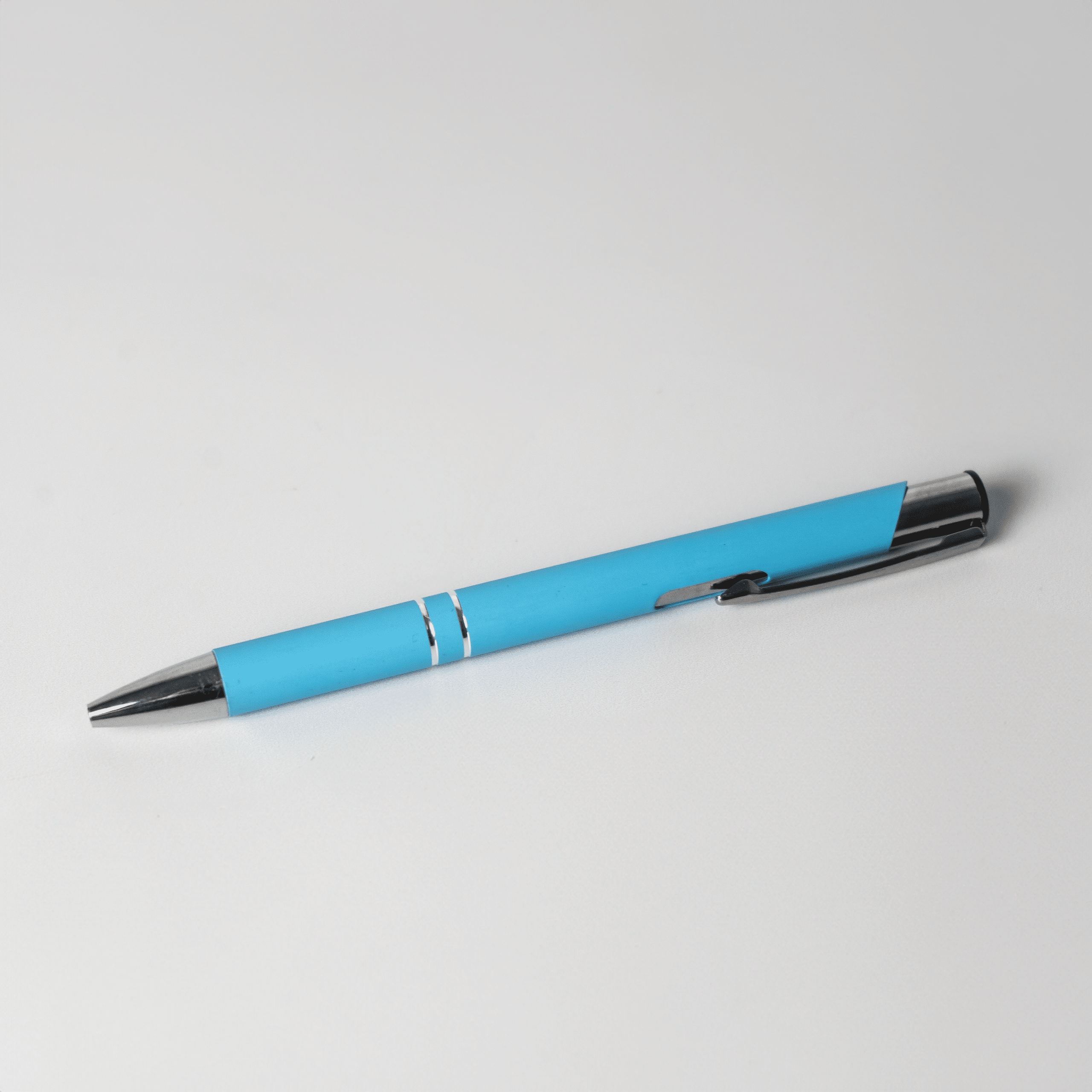 Light blue promotional pen with silver accents and clip on a white background, ideal for custom branded pens and corporate promotional merchandise.