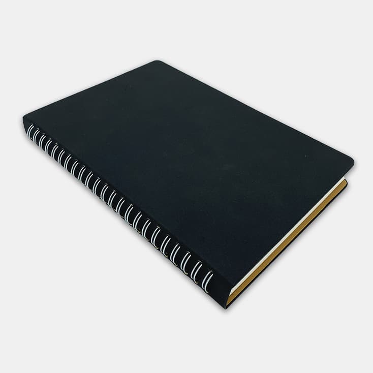 A black spiral notebook with a textured cover and contrasting white spirals along the spine.