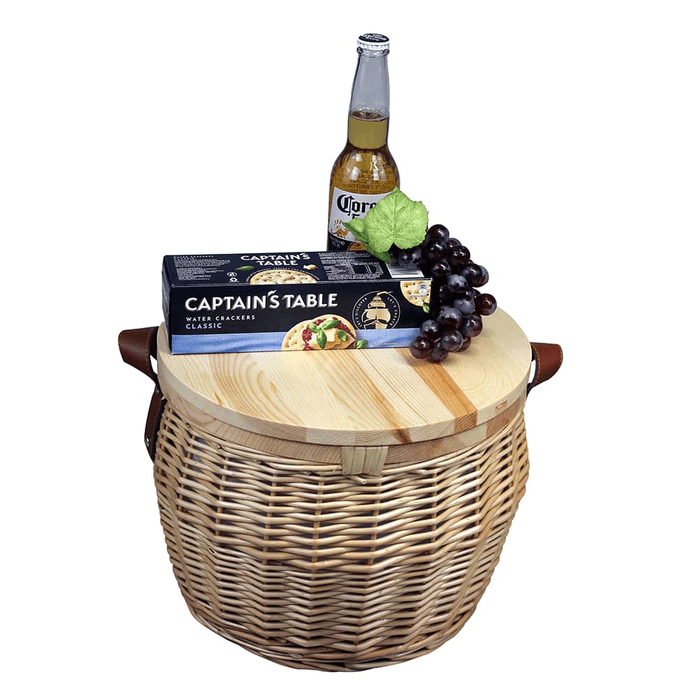 A wicker cooler basket in natural tones with a silver insulated interior and leather straps. It has a round lid.