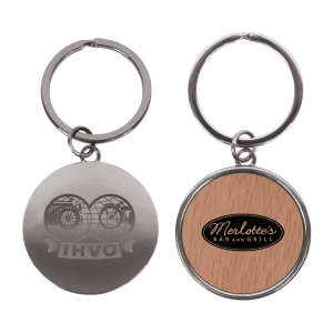 A round keychain in silver with a wood-patterned side featuring a logo and design elements.