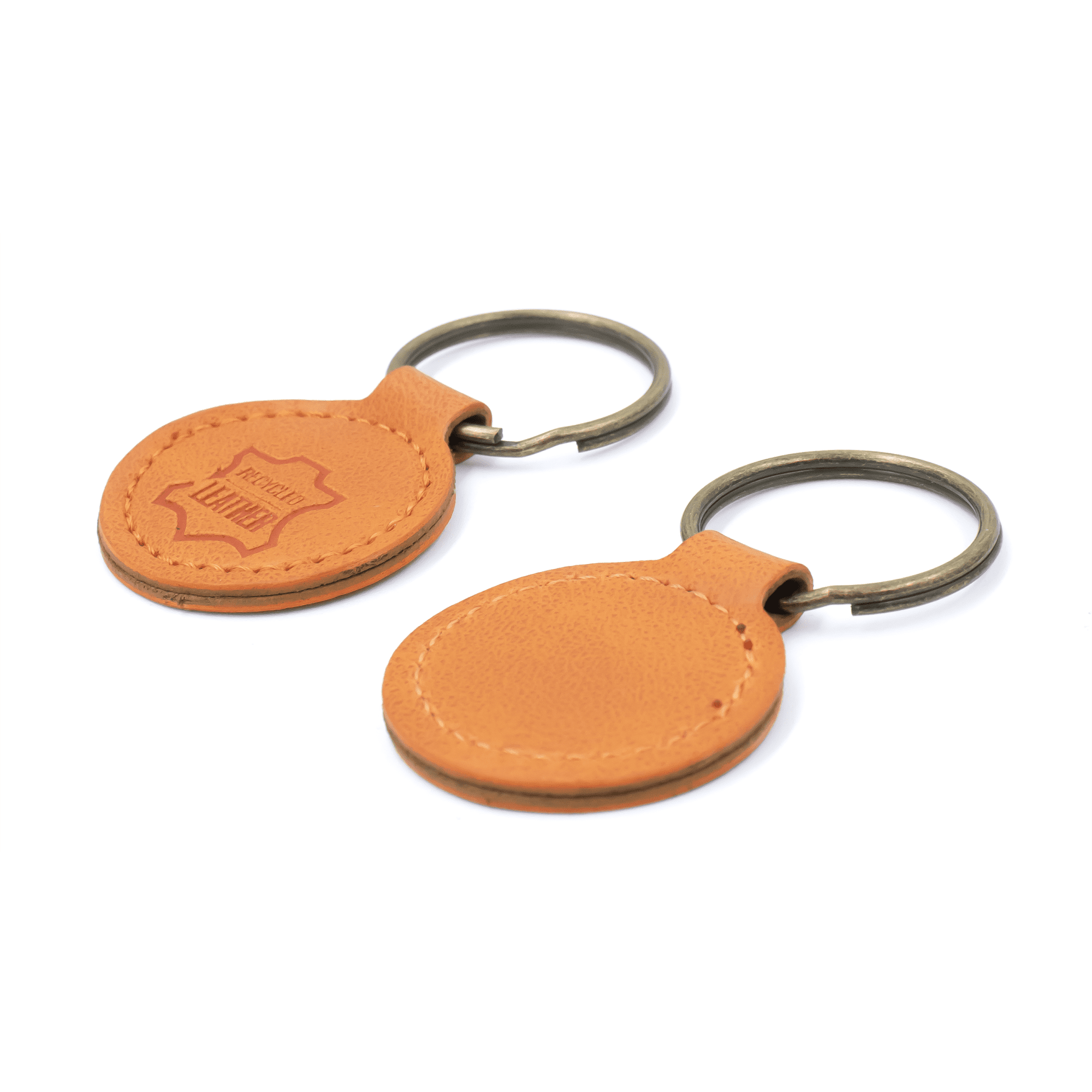 A tan recycled leather keyring with a metal keychain, featuring a branded logo on one side.