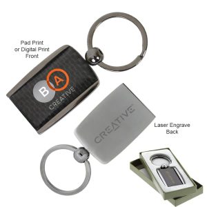 A carbon fibre keychain featuring a circular metal ring and a rectangular holder in silver and black, displayed in a gift box.
