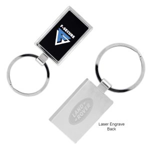 A silver keychain featuring a rectangular design with a logo, suitable for engraving on the back.