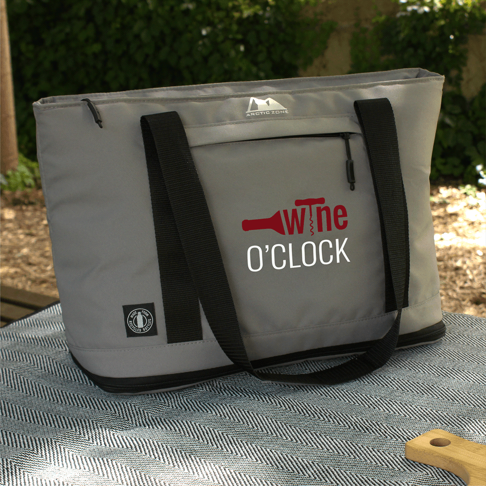 A grey cooler bag with black straps and a zipped top, featuring a logo and a tag.