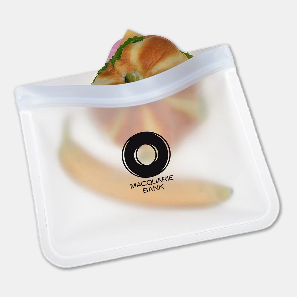 A clear PEVA reusable food storage bag containing a sandwich and a banana, featuring a logo.