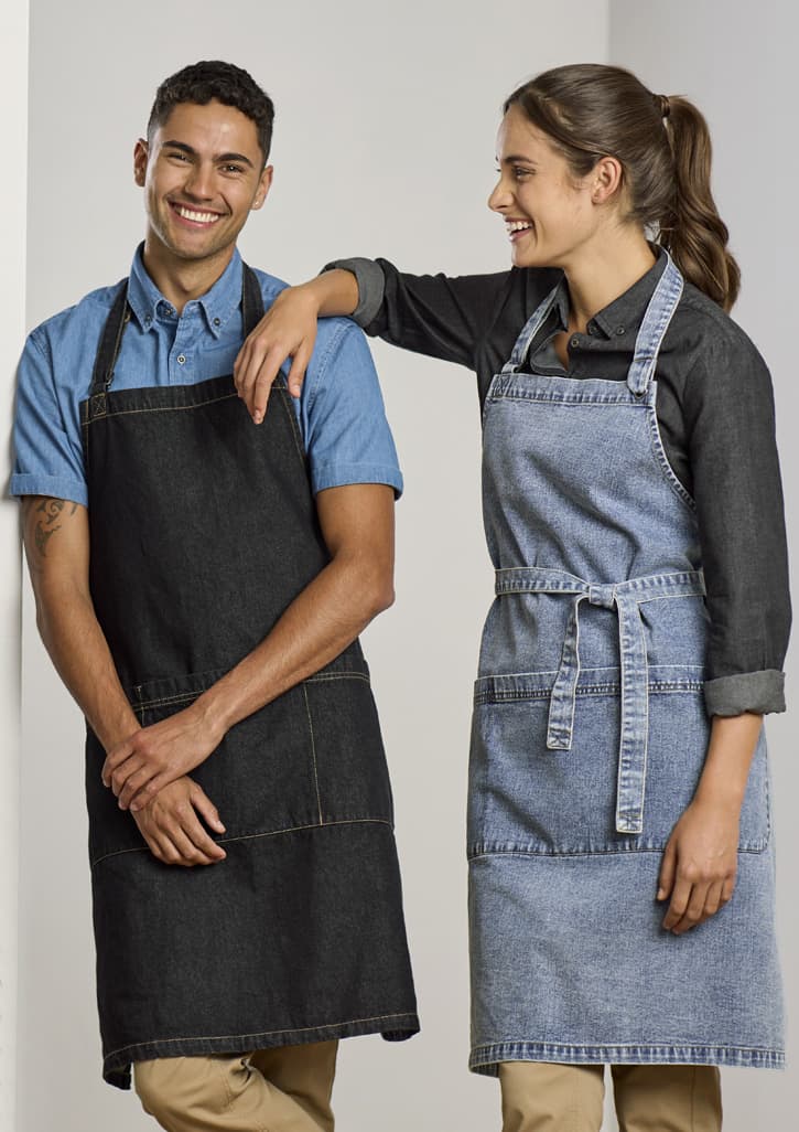 Two models wearing denim aprons, one in black and the other in light blue, against a plain background.