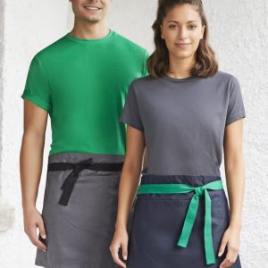 A green and navy urban waist apron worn by two models, featuring contrasting ties and a logo on one apron.