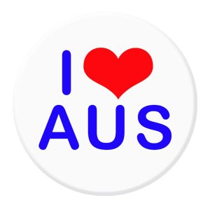 A 56mm button badge featuring a red heart and the text "I AUS" in blue on a white background, with a logo.
