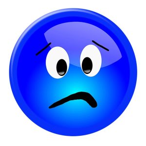 A blue button badge with a sad face design and a small logo in the corner.