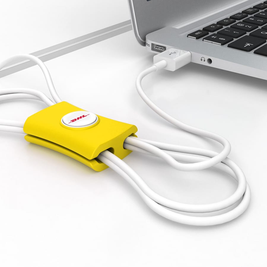 A yellow cable manager featuring loops for organising white cables, positioned next to a laptop.