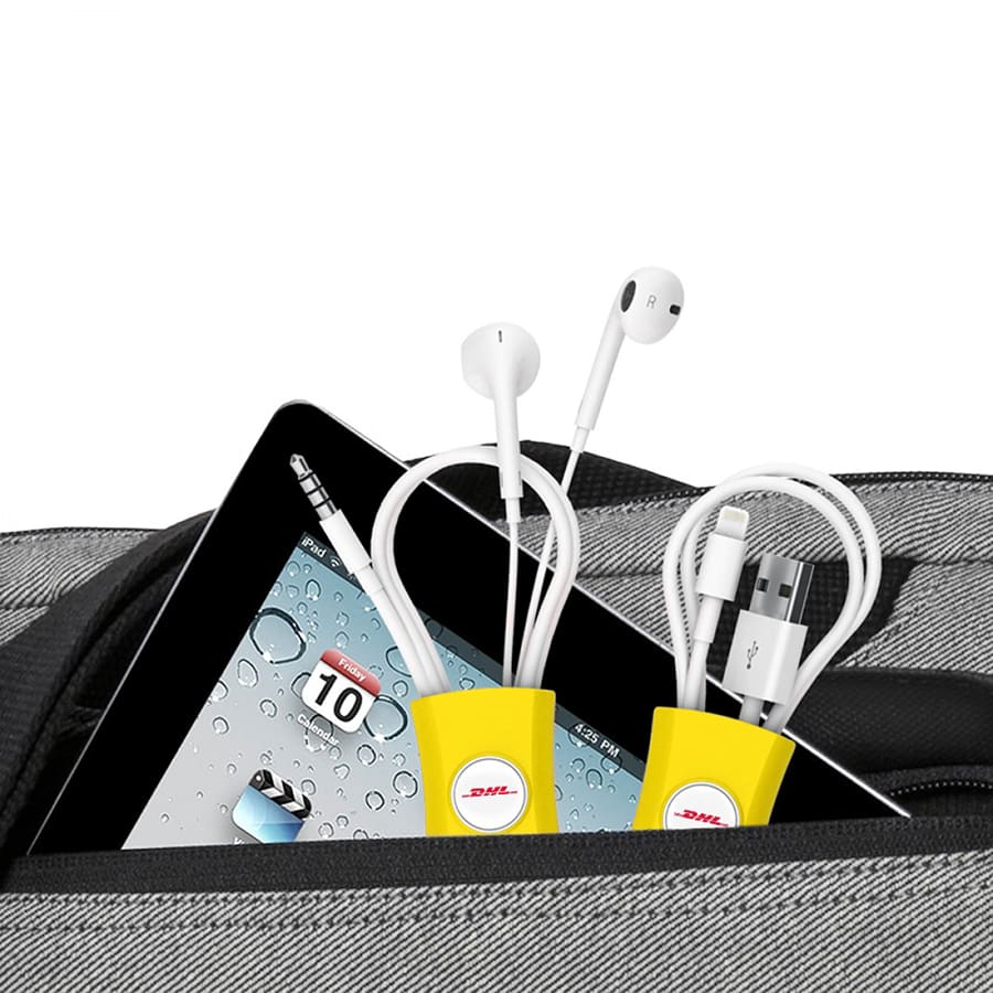 A yellow cable manager holds earbuds and charging cables within a grey bag featuring a tablet.