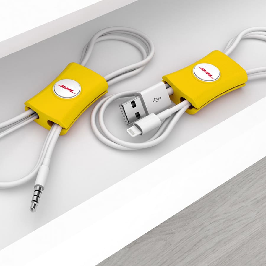 Yellow cable manager, featuring a circular logo, designed to tidy and organise cables. Two cables are neatly wrapped.