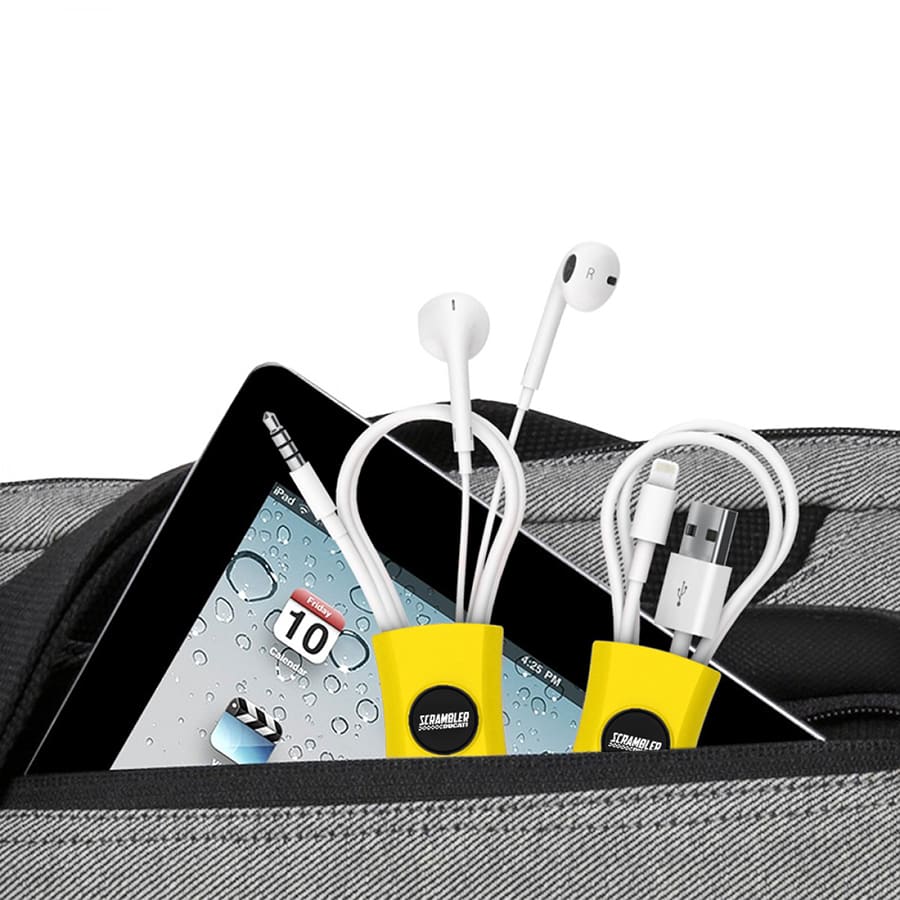A cable manager in yellow holding white charging cables and earphones, placed with a tablet in a bag.