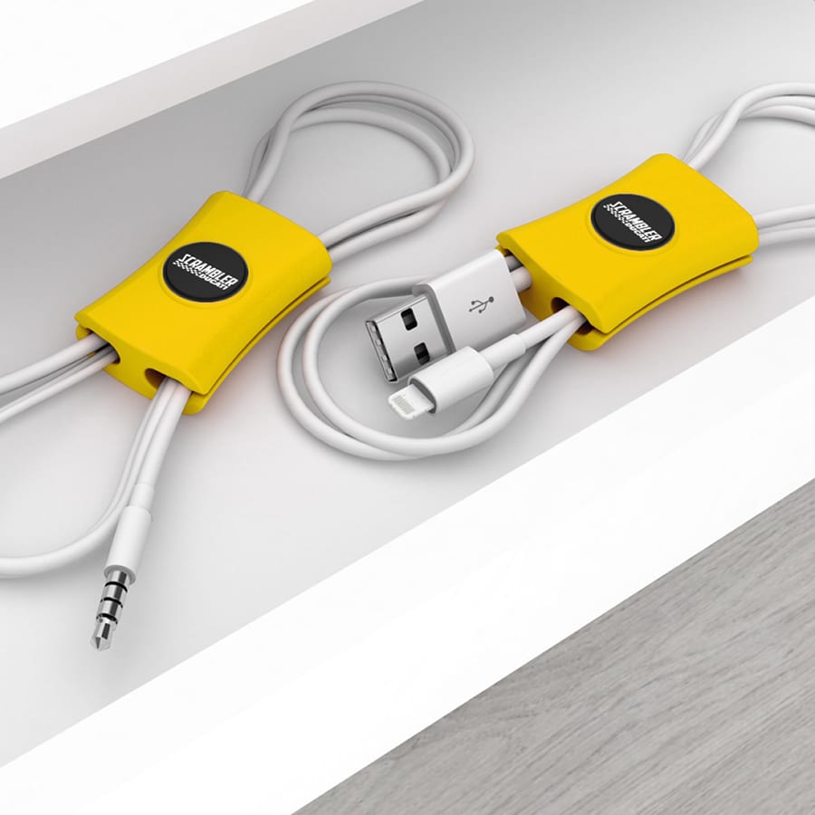 A yellow cable manager neatly holds and organises two charging cables. It features a logo on its surface.