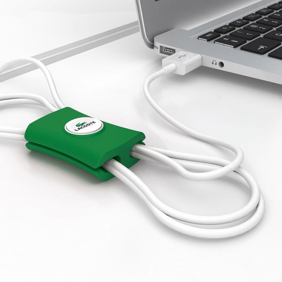 A green cable manager designed to organise and tidy multiple cables near a laptop. It features a branding logo.