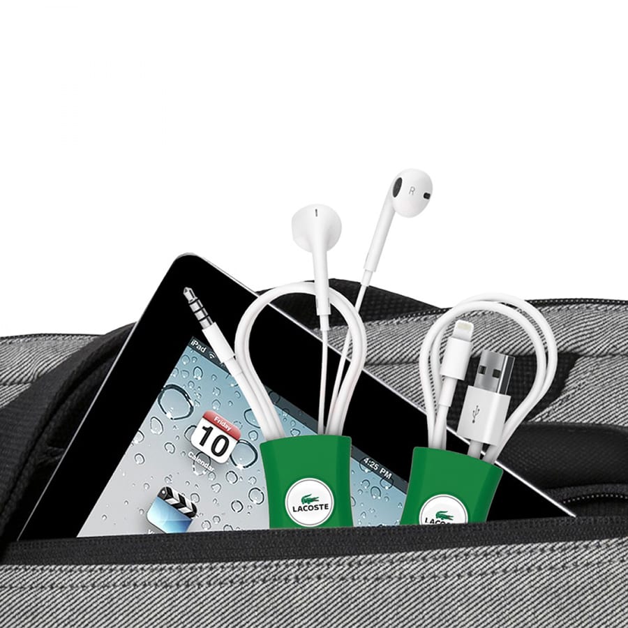 A cable manager in green, holding white earphones and cables, set against a grey bag and tablet background.