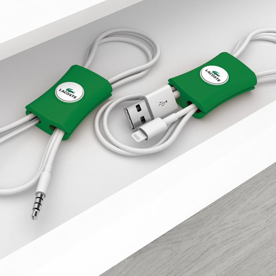 Green cable manager with rounded design, designed to tidy cables on a shelf, featuring a logo.