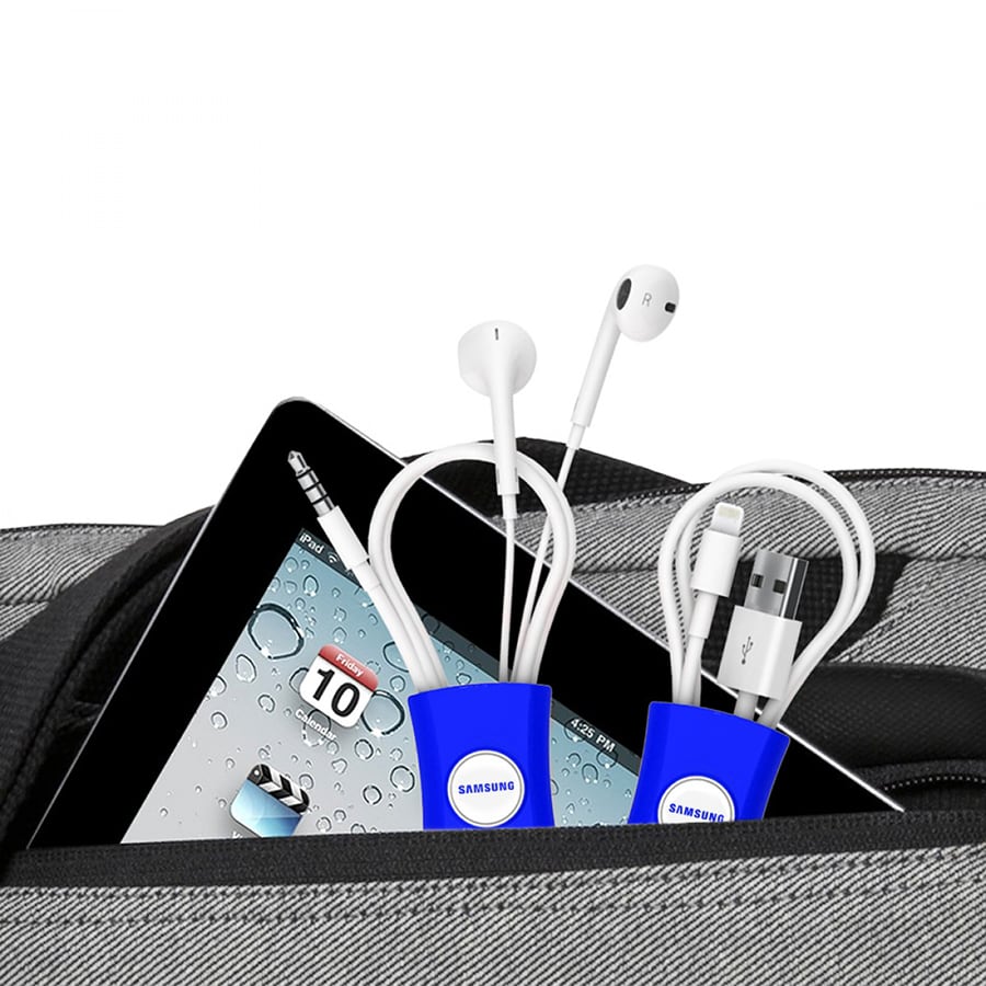 A blue cable manager holding earbuds and charging cables, placed inside a grey backpack alongside a tablet.