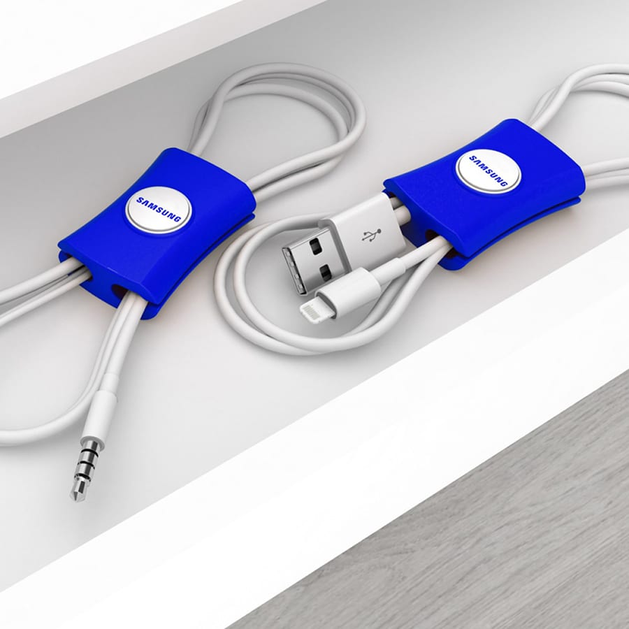 Cable manager in blue, designed to organise and tidy cables, featuring a logo, placed on a white surface.