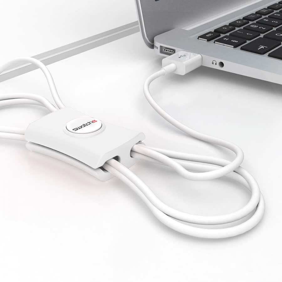 A white cable manager with multiple cables neatly organized, connected to a laptop.
