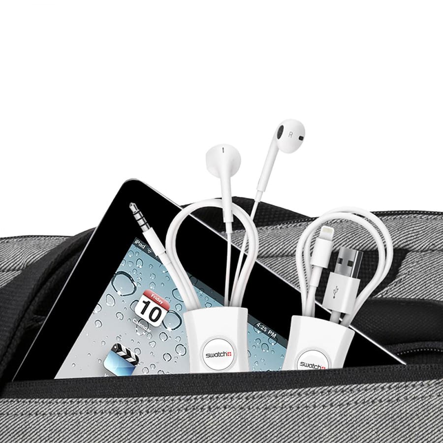A white cable manager for organizing earphones and charging cables, placed inside a grey bag alongside a tablet.