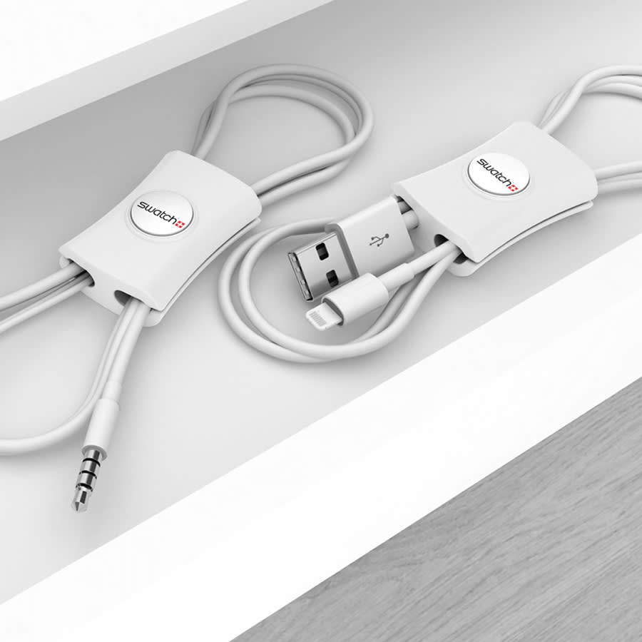 A white cable manager with a logo, designed to organise and tidy phone charging cables.