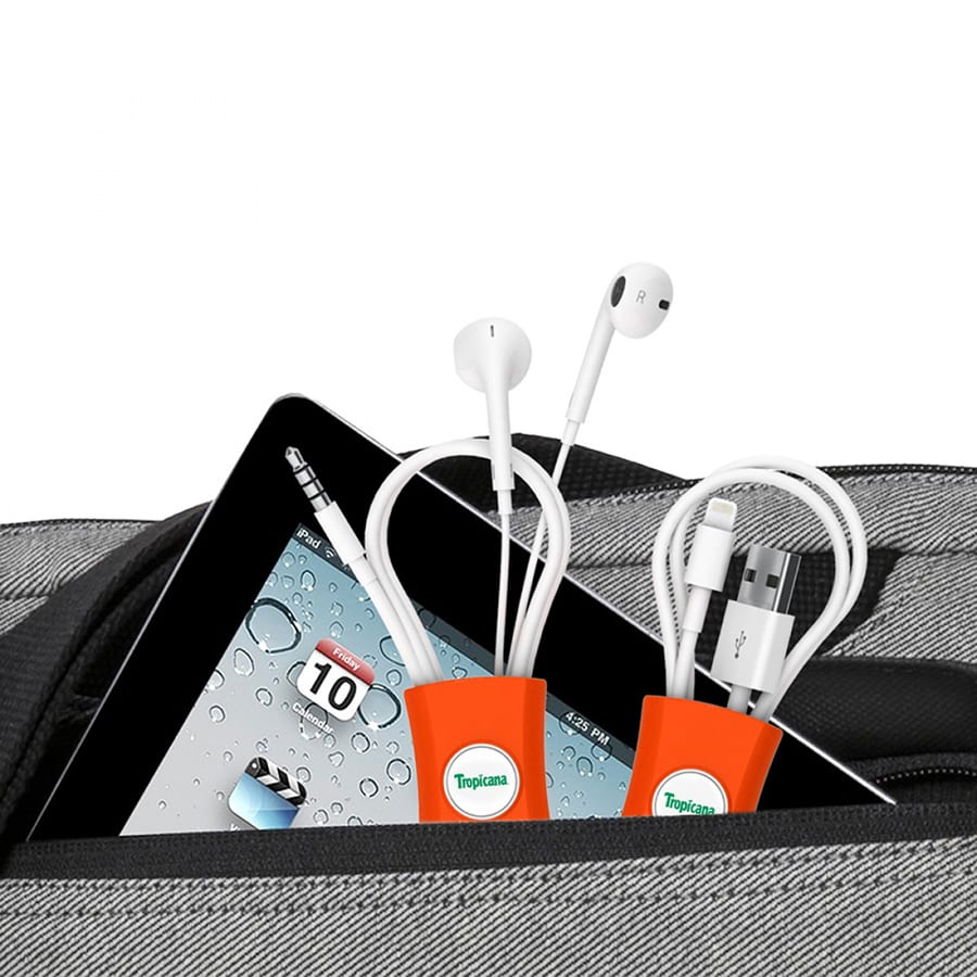 A cable manager in orange, holding headphones and charging cables, inside a grey bag with a tablet visible.