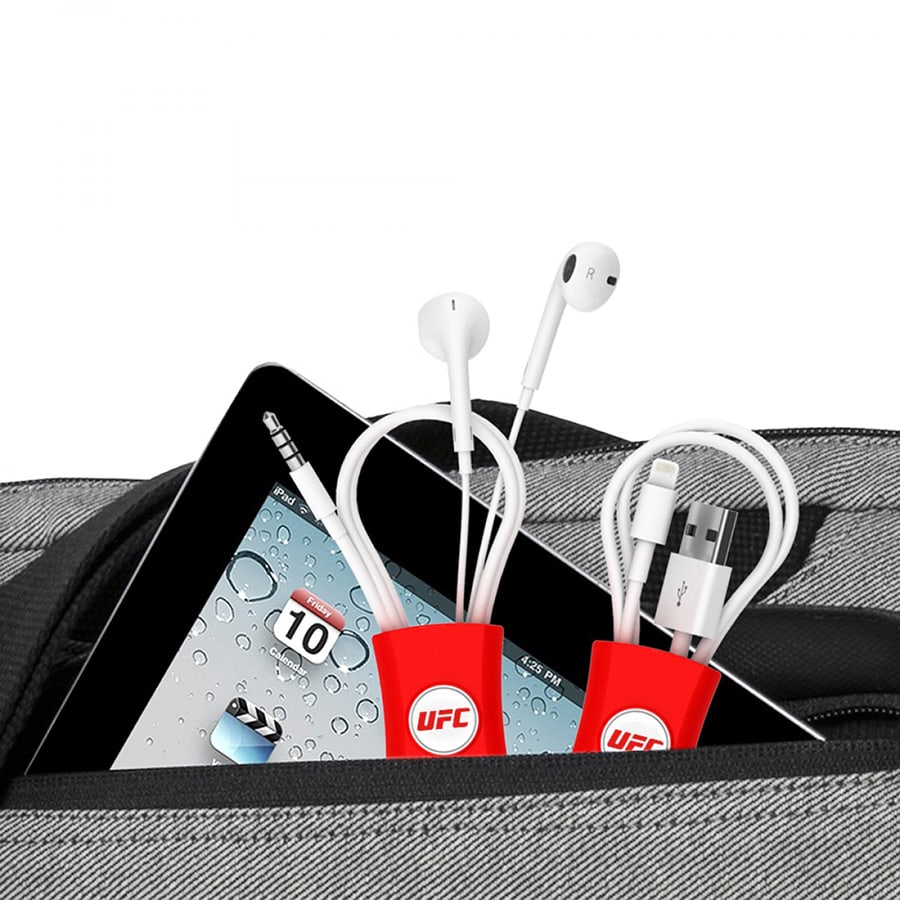 Red cable managers nestled in a grey bag, with white earphones and cables visible alongside a tablet screen.