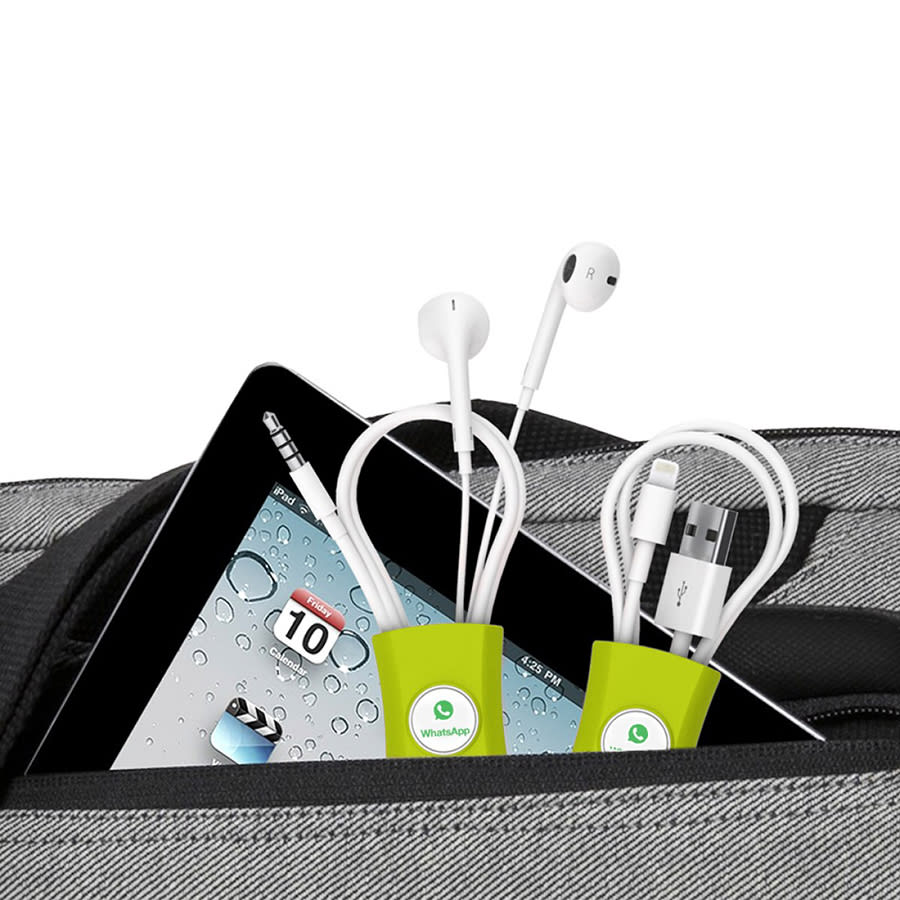A green cable manager holding earbuds and charging cables, placed next to a tablet in a grey bag.