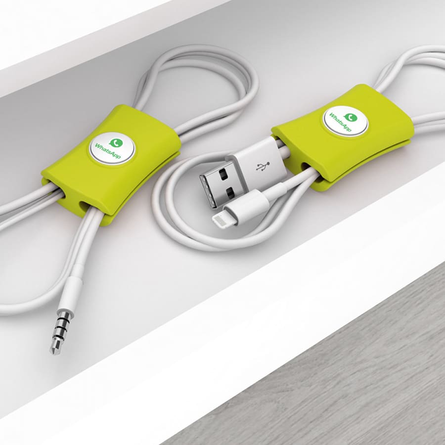 A green cable manager displaying two cords neatly organised inside a drawer, featuring a logo.