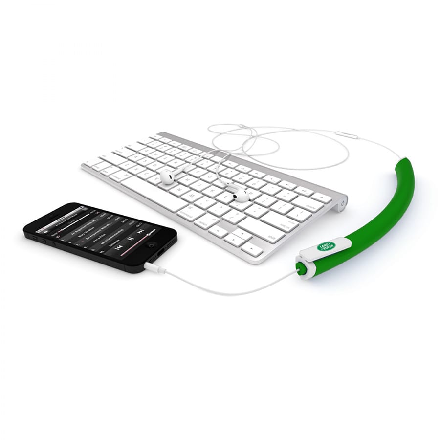 A green earbud organiser next to a smartphone and a keyboard, designed to tidy up cables.