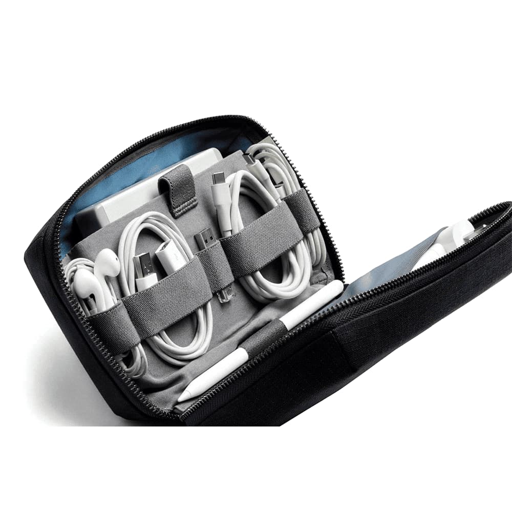 A black tech kit with a textured surface, featuring a zip closure and a branding logo, in a rectangular shape.