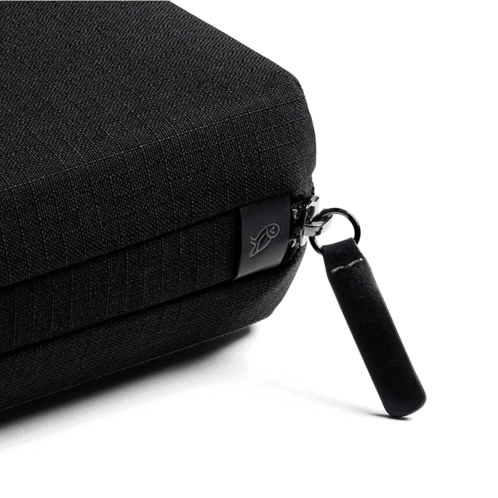 A black tech kit featuring a zippered compartment, blue lining, and pockets for organising small items and cards.
