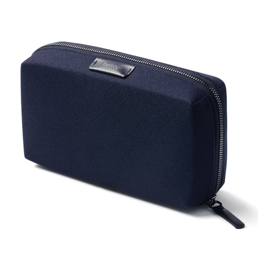A navy tech kit contains a mouse, chargers, cables, a power bank, and an assortment of memory cards.