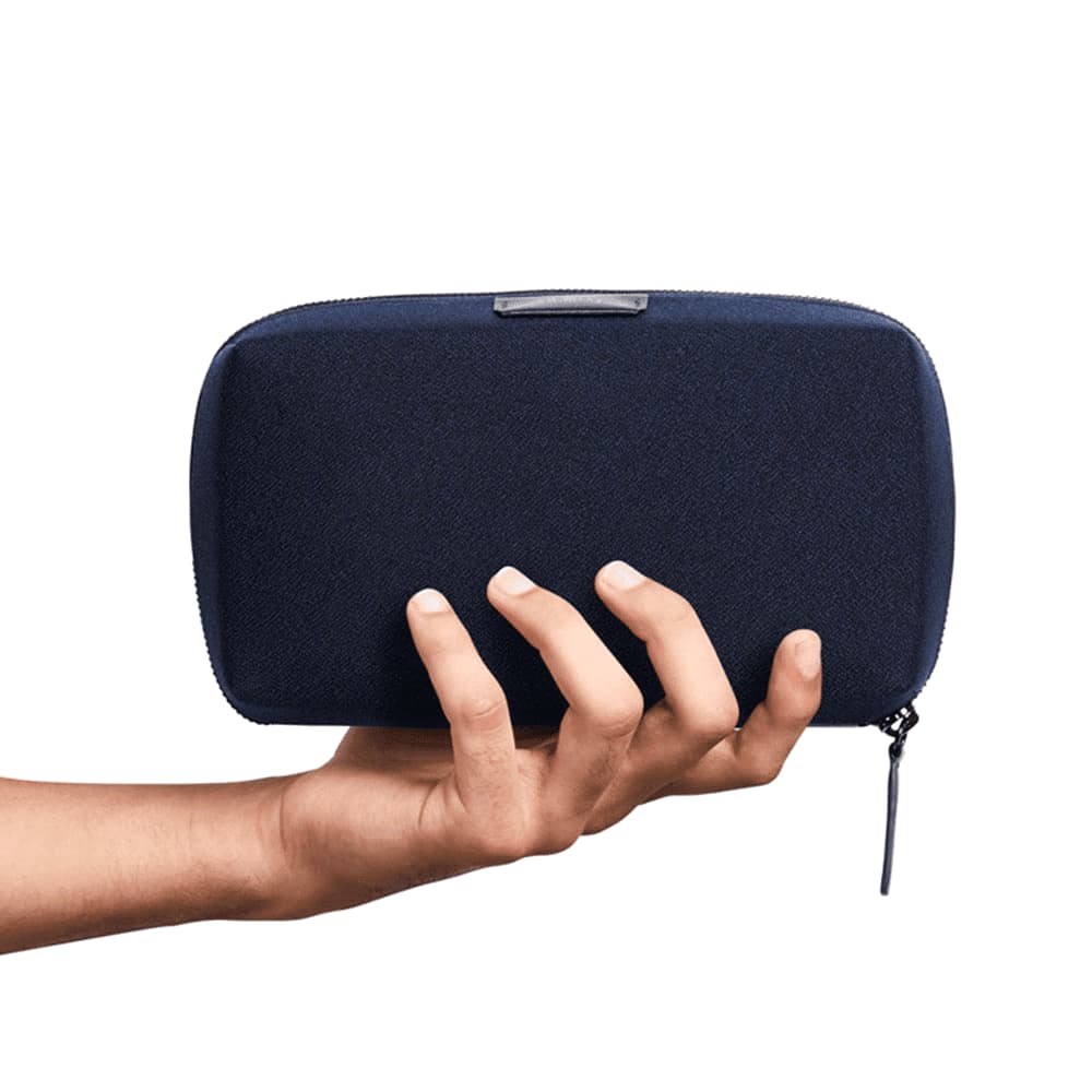 A navy blue tech kit with a textured surface and a zip closure. It features a logo on the front.