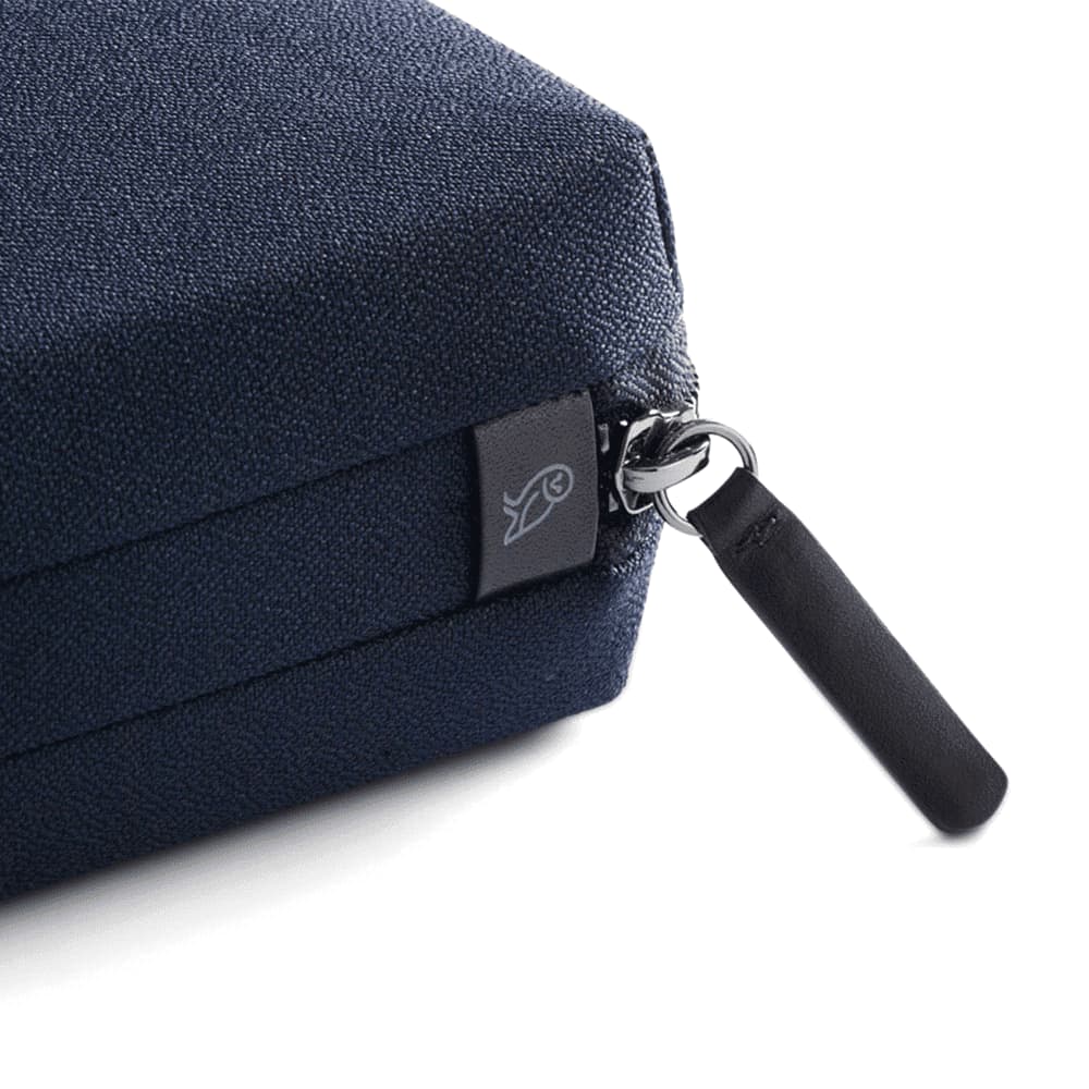 A black tech kit with a textured surface and a zip closure featuring a small black pull tab.