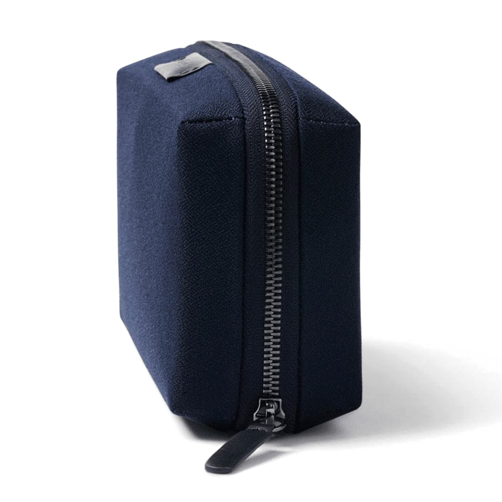A black tech kit with a structured shape and a zipper closure, featuring one logo on the side.