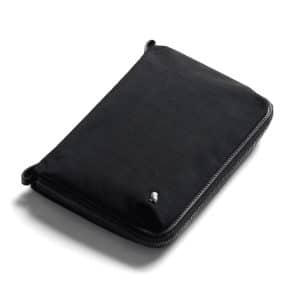 A black toiletry bag with a zip closure and a small logo. It features a sleek, minimalist design.