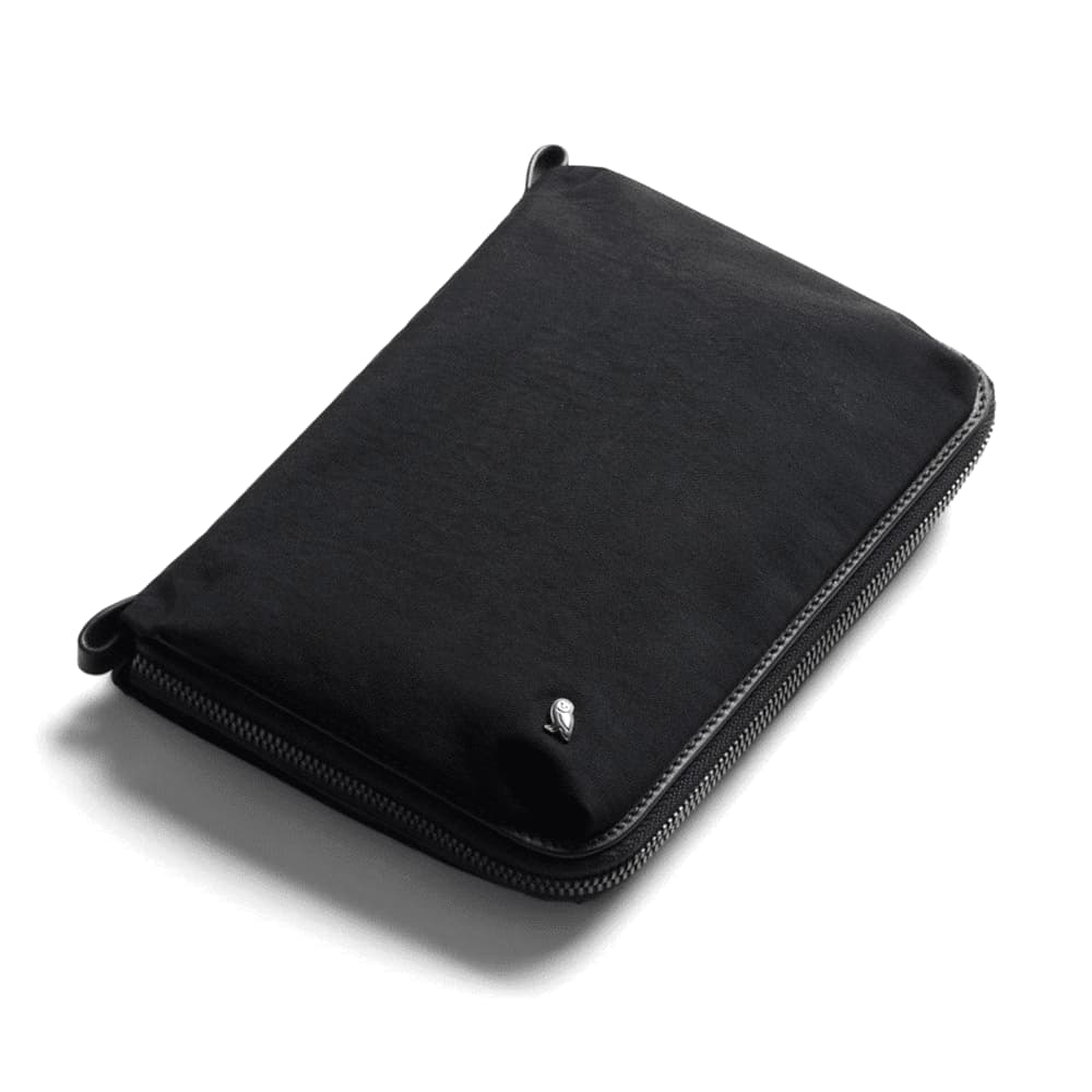 A black toiletry bag with a zip closure and a small logo. It features a sleek, minimalist design.
