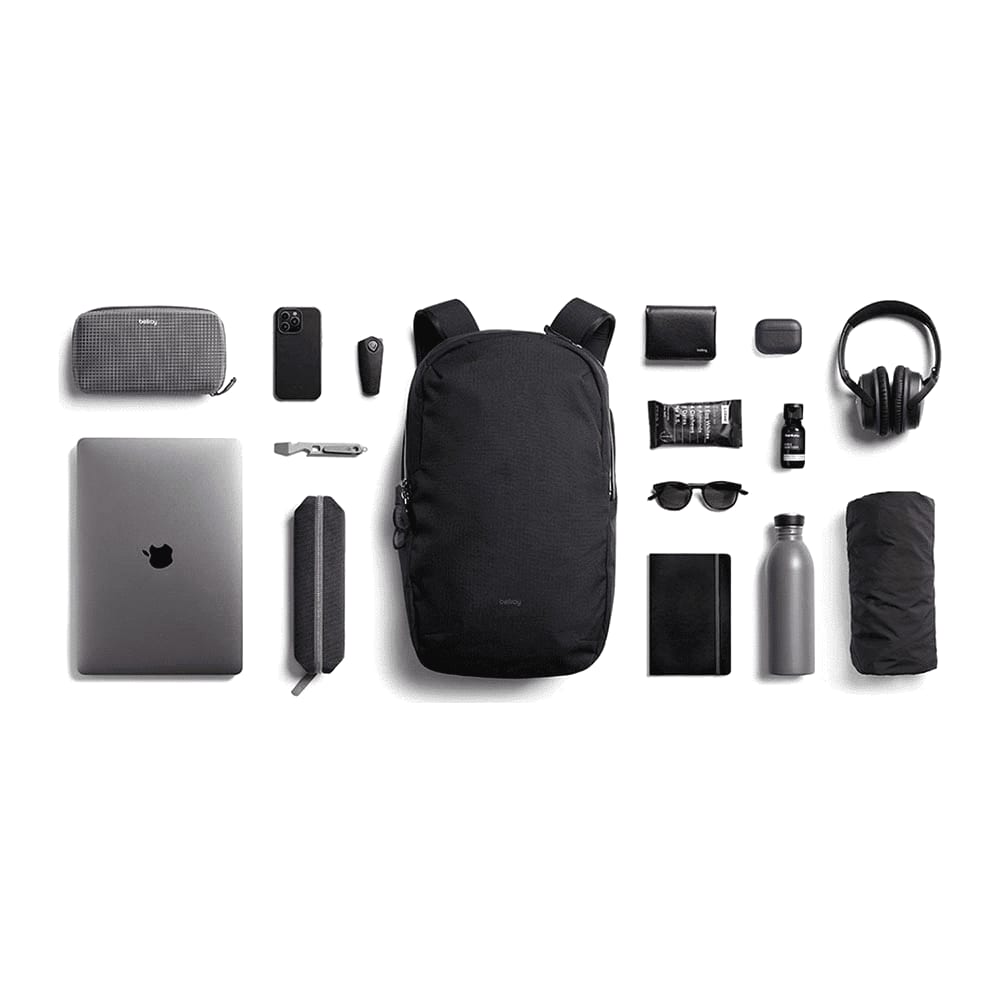 A person wearing a navy blue backpack, featuring padded shoulder straps and a simple design. The backpack has a logo.