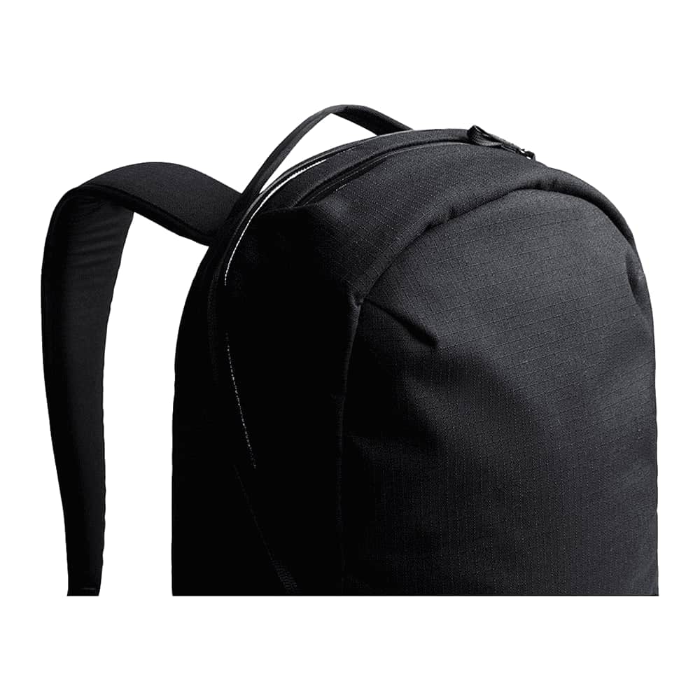 An open black backpack interior featuring a grey lining, small pockets, and various items like a wallet and a keychain.