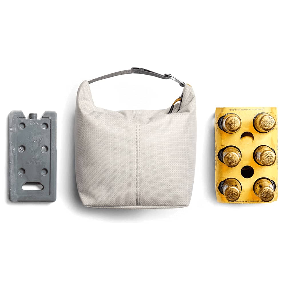 A light grey cooler bag with a logo, featuring a zip closure and a handle for easy carrying.